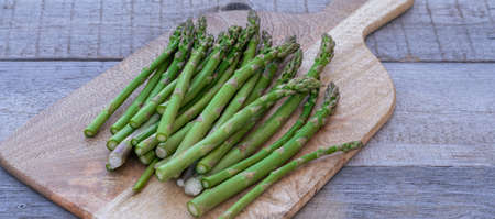 Frozen green asparagus on wooden desk background, flat lay, top view.の写真素材