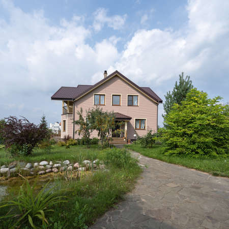 Country house with tiled roof and chimney in countryside.の写真素材