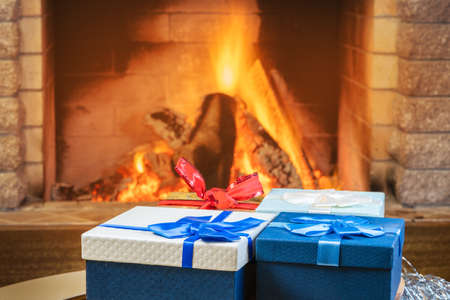Christmas eve. Gift boxes near cozy fireplace, in country house.の写真素材