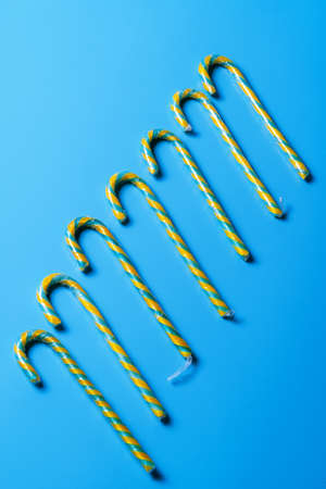 Flat lay Candy cane row on blue pastel background