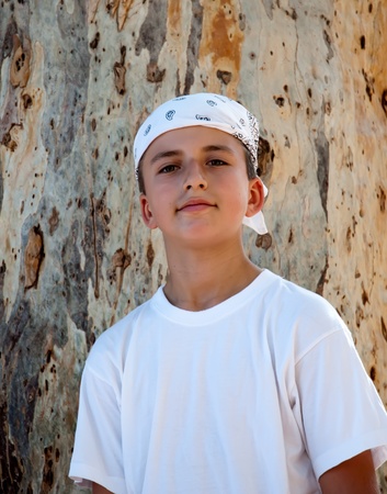Portrait of a Boy in the bandana on the background of the trunk of eucalyptus.の写真素材