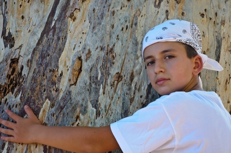 Portrait of a Boy in the bandana on the background of the trunk of eucalyptus.の写真素材