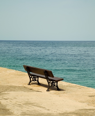 Empty wooden bench with a viewpoint looking out to sea.の写真素材
