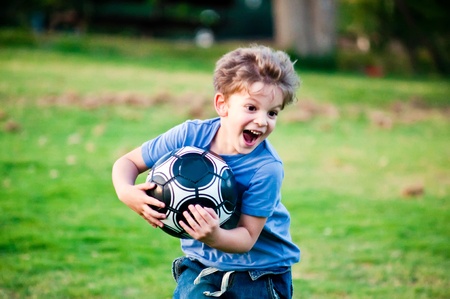 Cute little boy with a ball in a park .の写真素材