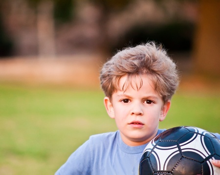 Cute little boy with a ball in a park .の写真素材