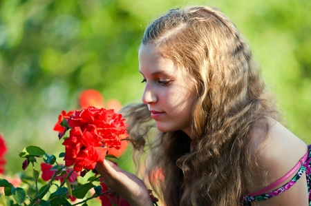 Portrait of a young girl in the garden of blooming roses.の写真素材