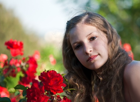 Portrait of a young girl in the garden of blooming roses.の写真素材