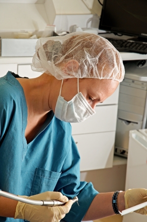 Beautiful dentist in uniform on background of medical office .の写真素材