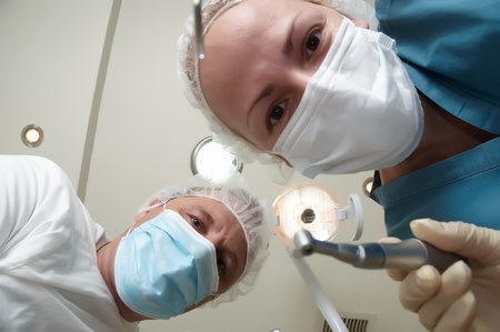 Patient from the dental chair view of the dentist and assistant.の写真素材