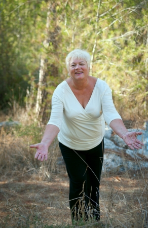 Smiling Senior woman exercising in leafy park .の写真素材