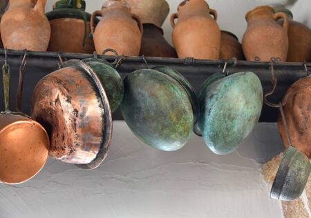 Various types of antique clay and copper utensils, ladles and jugs.