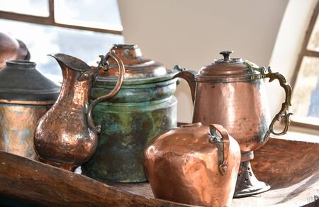 Different types of antique copper utensils, a coffee pot and a jug .
