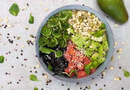 Poke bowl with smoked salmon, cucumber, avocado, sea kale, bean sprouts, baby spinach, sesame and...