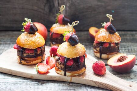 Sweet burgers with brioche bun, chocolate brownie layer, fresh strawberries and melted chocolate sauce.の写真素材