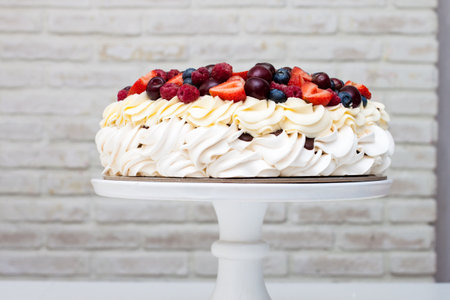Meringue Pavlova cake with whipped cream and fresh berries, strawberries, blueberries, raspberries...