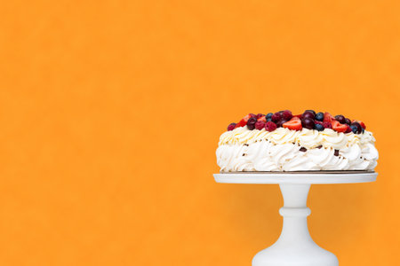 Meringue Pavlova cake with whipped cream and fresh berries isolated, strawberries and blueberries on...