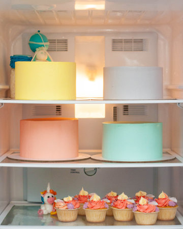 Pastry chef fridge with set of assorted colorful cakes before decorationの写真素材
