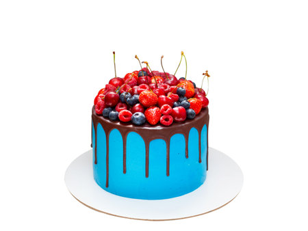 Beautiful blue birthday cake decorated with fresh berries with a place for a label. The concept of summer desserts for a birthdayの写真素材