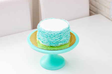 Exquisite birthday Cake Decorated with Green and turquoise Fondant Ruffles on white background
