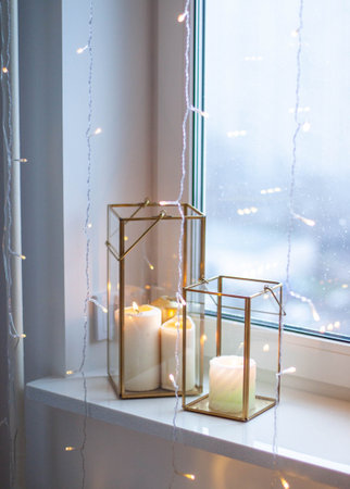 Christmas table setting with burning candles, retro lights and champagne glasses. Warm and cozy atmosphereの写真素材