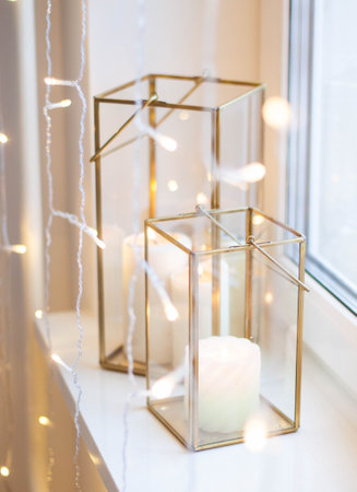 Christmas table setting with burning candles, retro lights and champagne glasses. Warm and cozy...