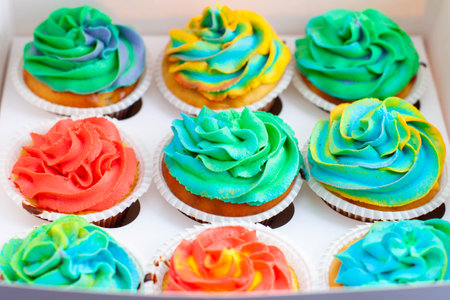 Colorful funny rainbow cupcakes in a gift cardboard box. Idea for a gift