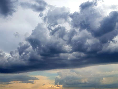 Blue dark storm clouds against the setting sun.
