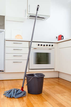 Cleaning parquet floor with rope mop. Microfiber mop with wringer and bucket of water for cleaning...