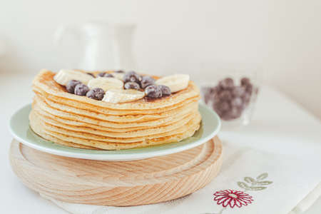 Delicious sweet food dessert pancakes or cornmeal pancakes, diet product, sweet food, holiday baking. Pancakes with fresh blueberries, banana and honeyの写真素材