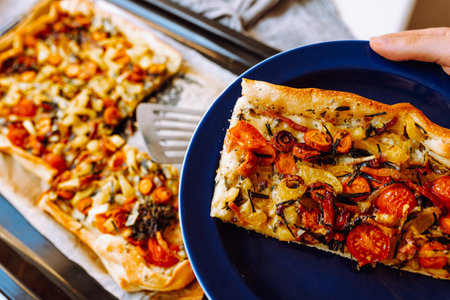 Spicy pie with vegetables, mushrooms, carrots, spinach and cheese on baking paper on light backgroundの写真素材