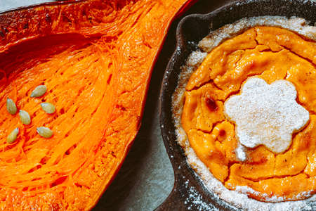 Baked pear-shaped pumpkin, pumpkin pie in pan, on baking sheet. Vegetarian baked rustic food, bright orange vegetable, pumpkin soup ingredientの写真素材