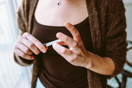 hands young girl filing nails. Close up young woman with manicure holding nail file in handsの写真素材