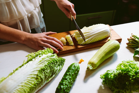 Woman cutting vegetables in the kitchen. Healthy eating and dieting concept.の写真素材