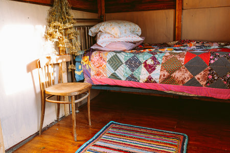 Interior of a rustic bedroom with a bed and pillowsの写真素材
