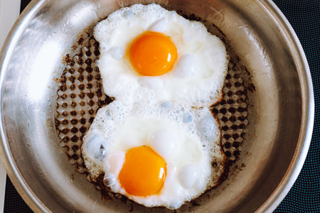 Fried eggs in a pan on the table. top view.の写真素材