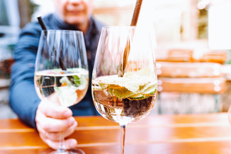 Two glasses of wine in the hands of a man in a restaurantの写真素材
