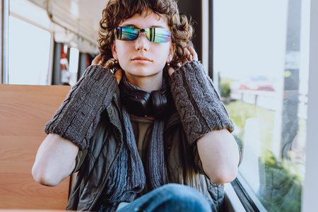 young handsome hipster teenager girl listening to music in the city bus, lifestyle people conceptの写真素材