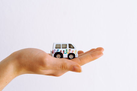 Womans hand holding minibus toy carの写真素材