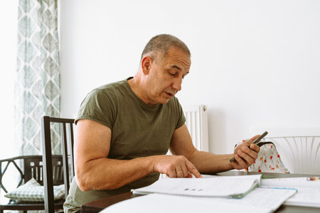 middle-aged man writes notes in notebookの写真素材