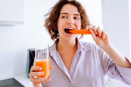 Portrait teenager girl biting fresh carrotの写真素材