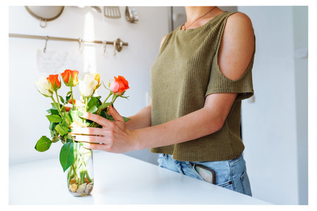 Portrait girl with bouquet of multi-colored roses at homeの写真素材