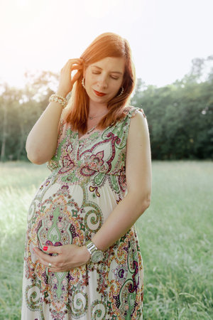 Portrait young happy pregnant woman on background natureの写真素材