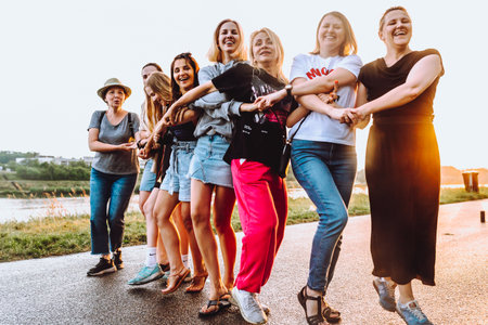 dancing cheerful attractive women at sunset.の写真素材