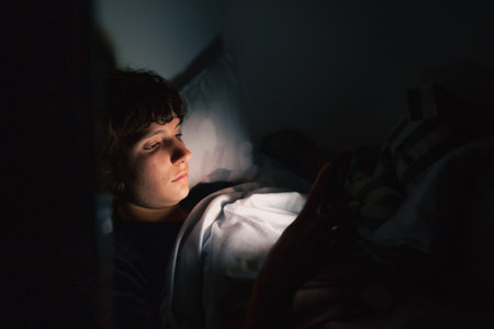 teenager uses gadget in darkの写真素材