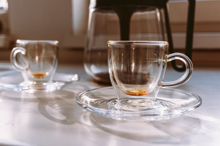 empty glass coffee cups and coffee pot on tabletopの写真素材
