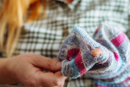 Woman sewing up hole in clothes, handmade
