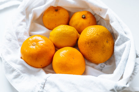 tangerines in fabric bagの写真素材