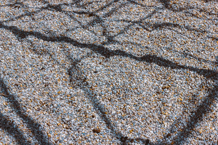 fine gravel texture with shadows from grateの写真素材