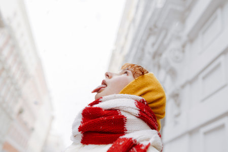 Positive portrait teenage girl in snowfall cityscapeの写真素材