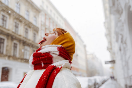 Positive portrait teenage girl in snowfall cityscapeの写真素材
